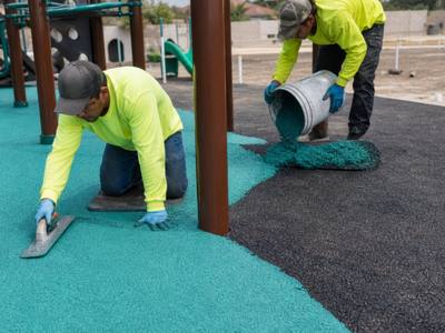 Teal rubber surfacing going in under play equipment