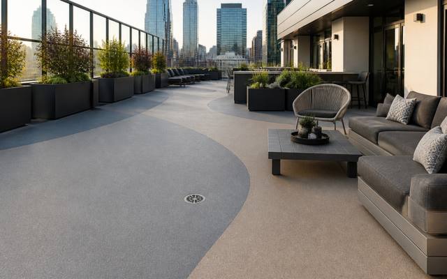 A condo rooftop terrace in grey rubber surfacing with the skyline behind it.